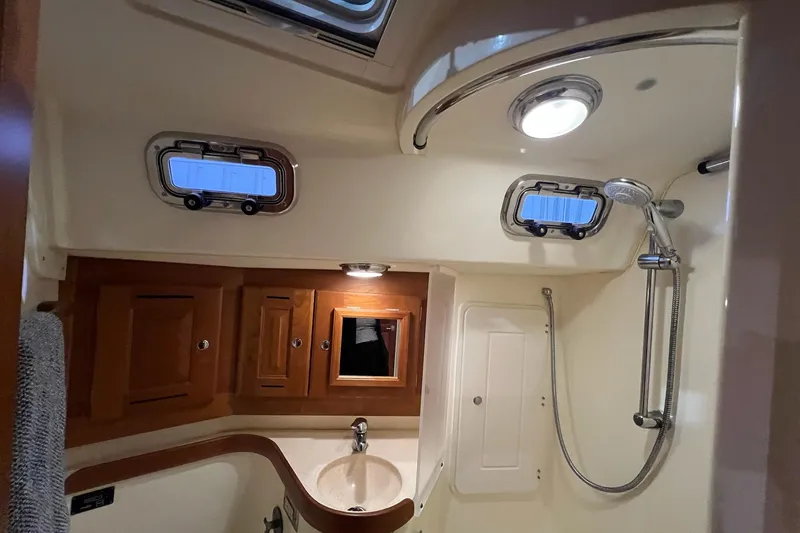 Slide: The Image of Luxurious 2017 Tartan 4300 yacht bathroom with shower, sink, and wooden cabinets. - 20