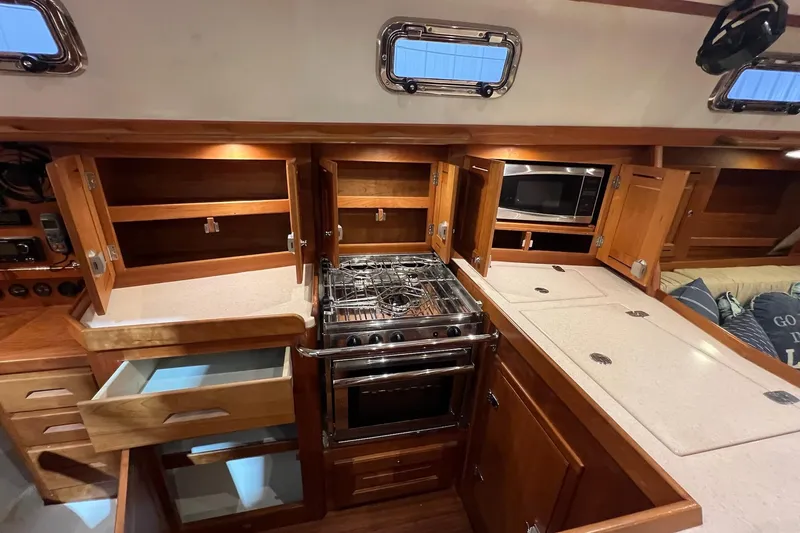 Slide: The Image of 2017 Tartan 4300 yacht kitchen with wooden cabinets, stove, and microwave. - 39