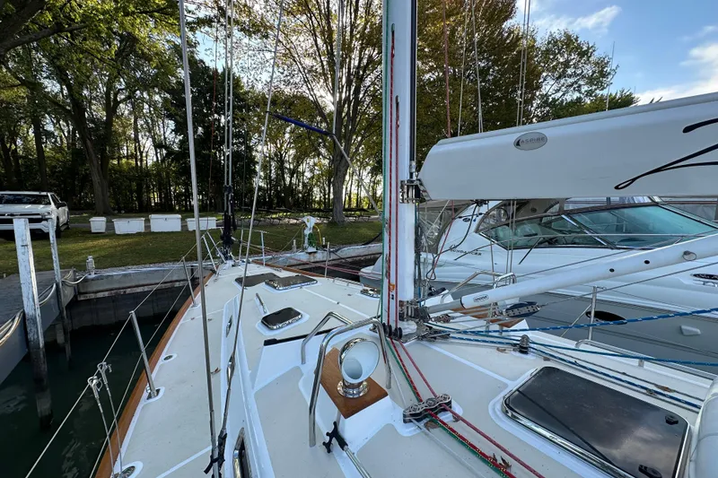 Slide: The Image of Sailboat docked in marina, Tartan 4300 model, 2017, surrounded by trees and other boats. - 4