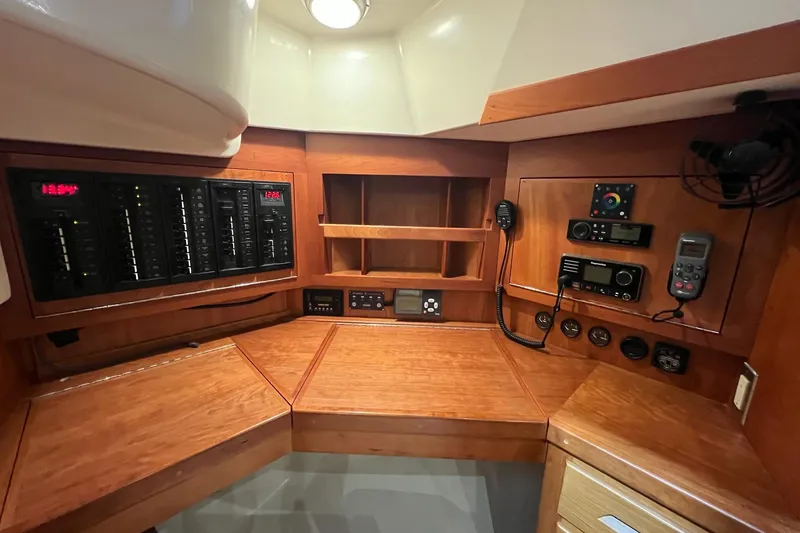 Slide: The Image of Control panel of a 2017 Tartan 4300 yacht with wooden cabinetry and electronic equipment. - 48