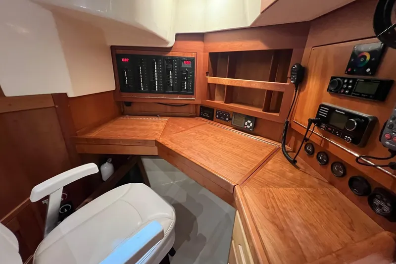 Slide: The Image of Navigation station of 2017 Tartan 4300 yacht with control panels and wooden finish. - 49