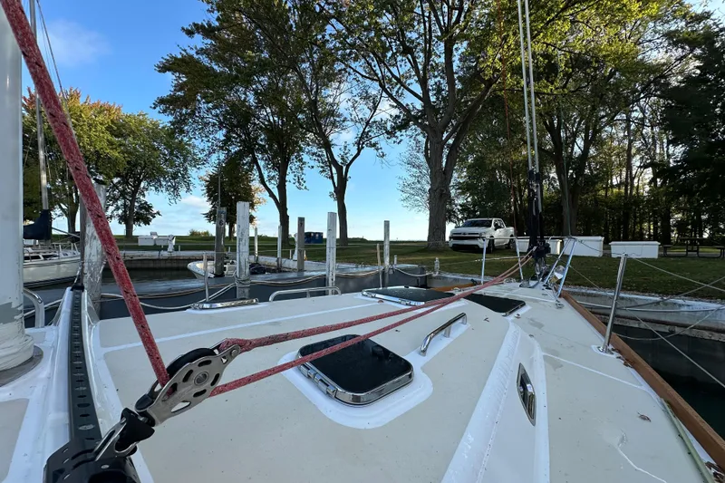 Slide: The Image of Sailboat Tartan 4300 (2017) docked near trees and parked vehicle. - 5