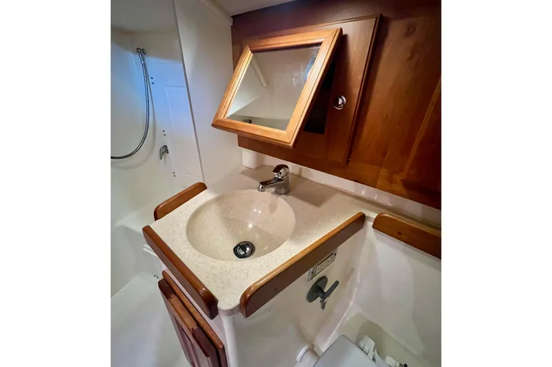 Slide: The Image of 2017 Tartan 4300 yacht bathroom with wooden cabinets and a sink. - 52