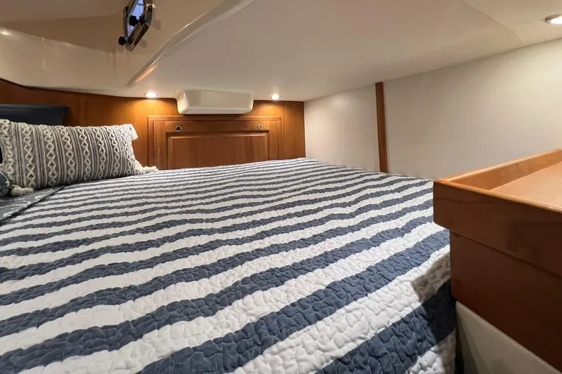 Slide: The Image of Cozy cabin interior of 2017 Tartan 4300 yacht with striped bedding and wooden accents. - 60
