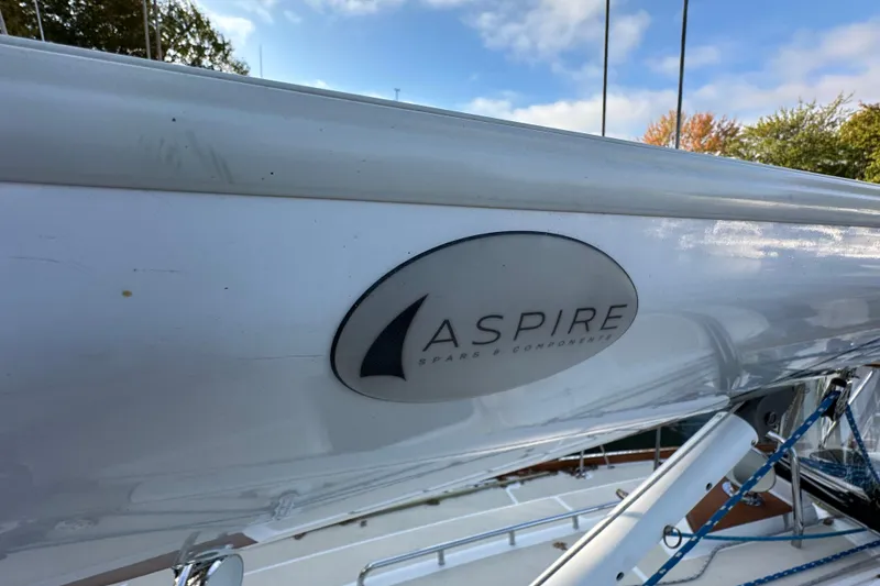Slide: The Image of Sailboat mast with "Aspire" logo, Tartan 4300, 2017 model, under clear sky. - 7