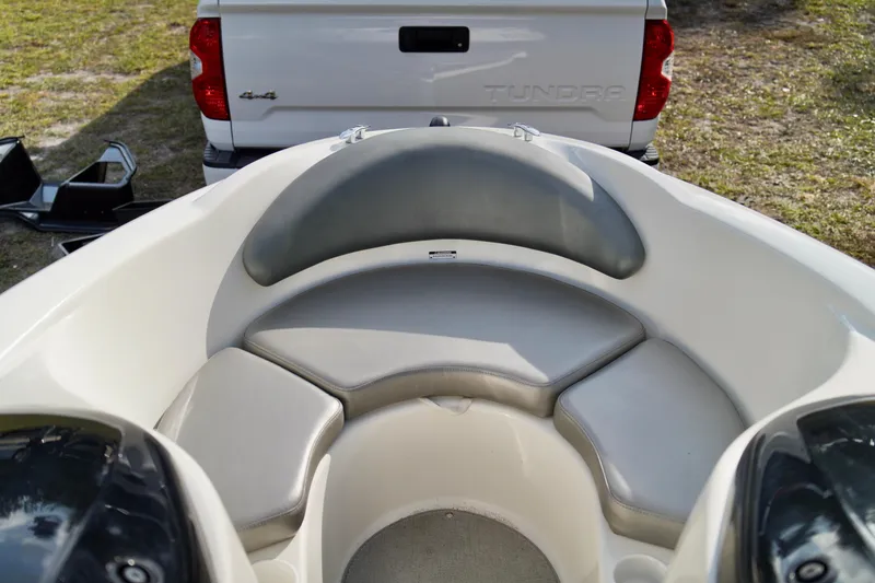 Slide: The Image of Interior of a 2001 Bombardier 1800 Challenger boat with seating, parked near a white truck. - 10