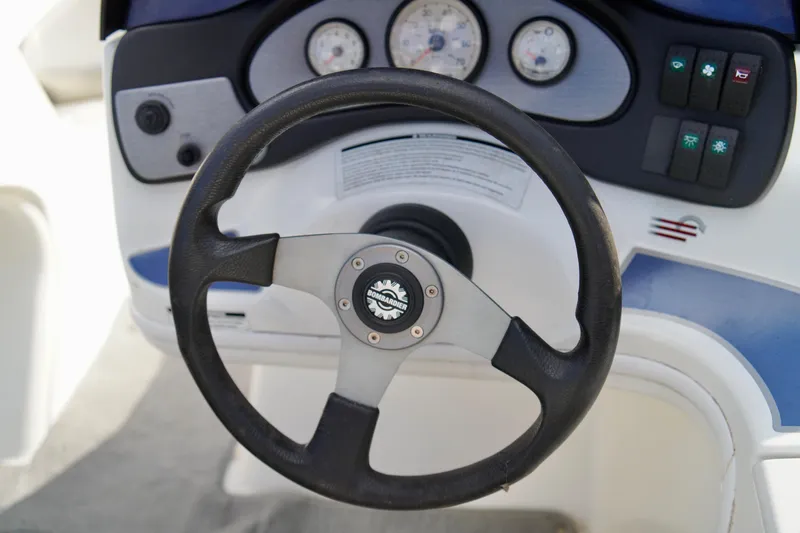 Slide: The Image of Steering wheel of a 2001 Bombardier 1800 Challenger boat with dashboard controls. - 12