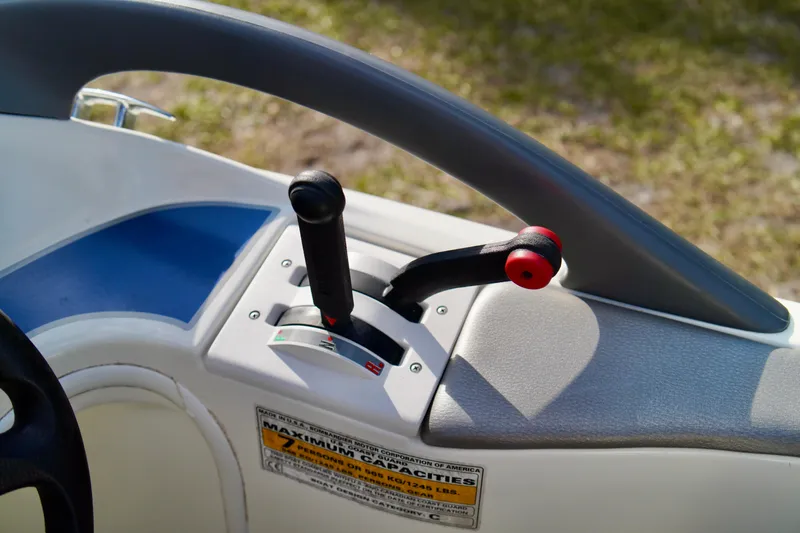 Slide: The Image of Control panel of a 2001 Bombardier 1800 Challenger boat with levers and capacity label. - 16