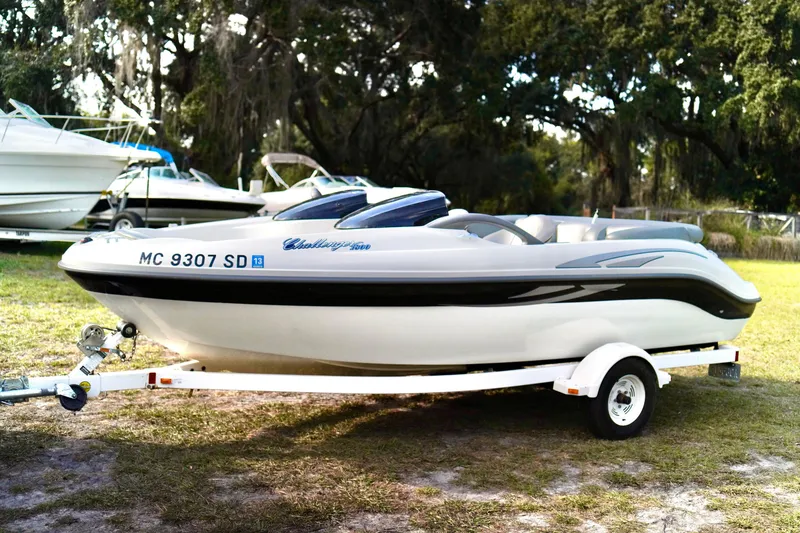 Slide: The Image of 2001 Bombardier 1800 Challenger boat on trailer, parked outdoors. - 2