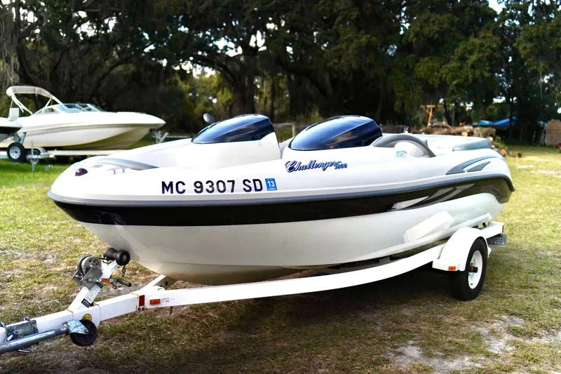 Slide: The Image of 2001 Bombardier 1800 Challenger boat on trailer, parked on grass. - 3