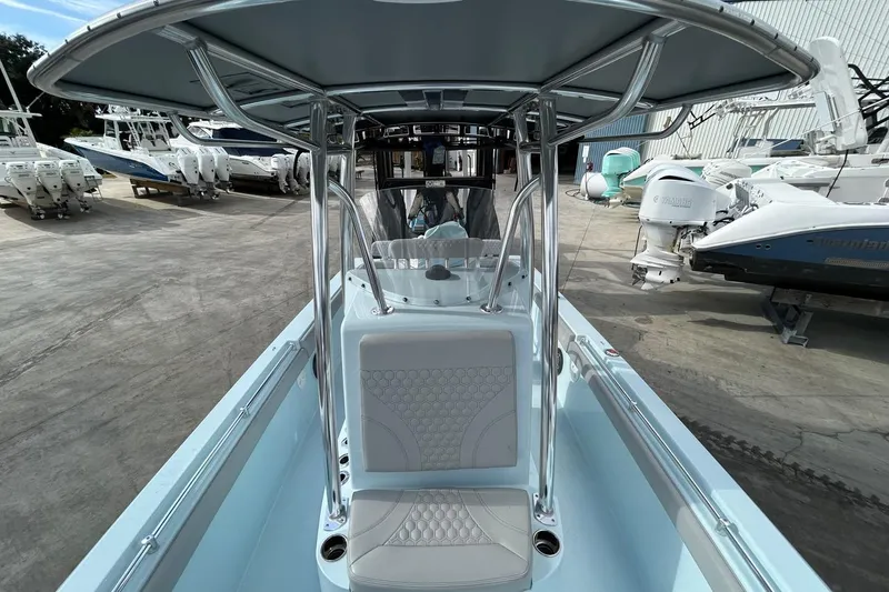 Slide: The Image of 2024 Contender 24 Sport boat with T-top and seating, displayed in a marina. - 14