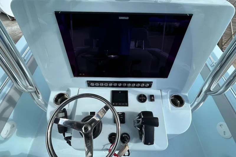 Slide: The Image of 2024 Contender 24 Sport boat console with steering wheel and navigation controls. - 17