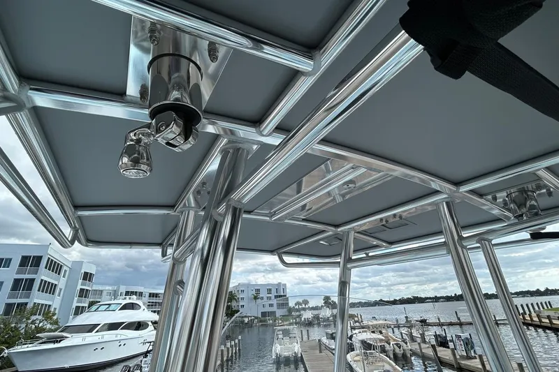 Slide: The Image of 2024 Contender 24 Sport boat with sleek metal framework at a marina. - 18