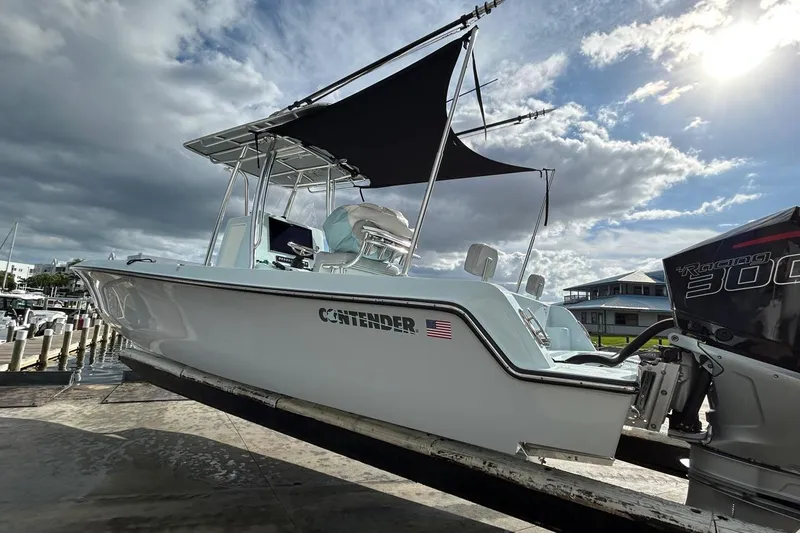 Slide: The Image of 2024 Contender 24 Sport boat with canopy, docked under cloudy sky. - 5