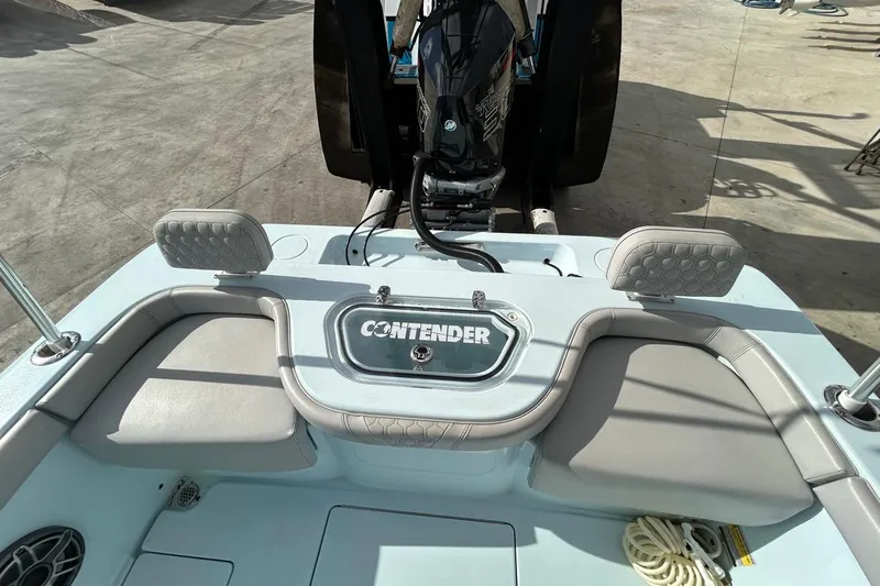 Slide: The Image of 2024 Contender 24 Sport boat interior with seating and engine view. - 7