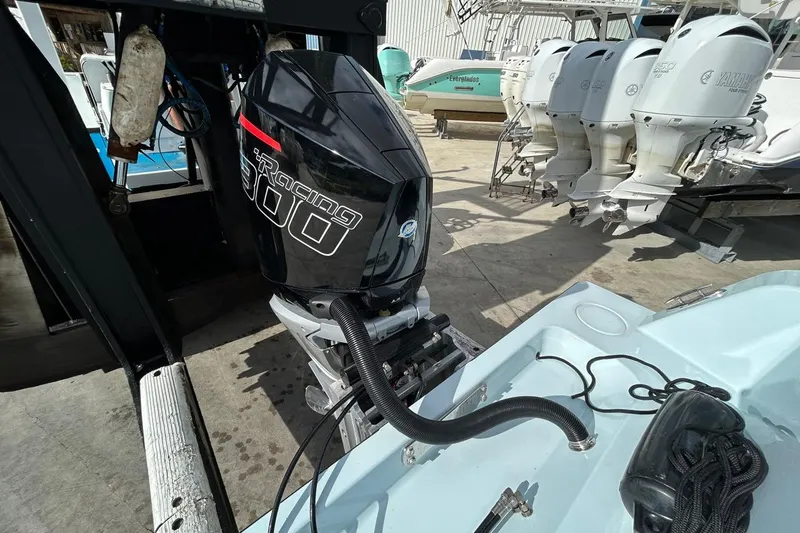 Slide: The Image of 2024 Contender 24 Sport with powerful outboard motor in a boatyard setting. - 8