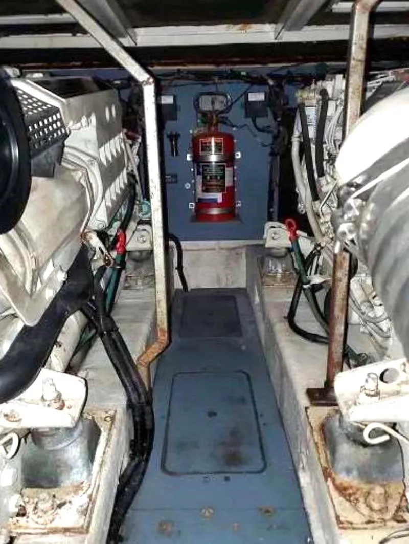 Slide: The Image of Engine room of a 1998 Viking Sports Cruiser with visible machinery and fire extinguisher. - 22