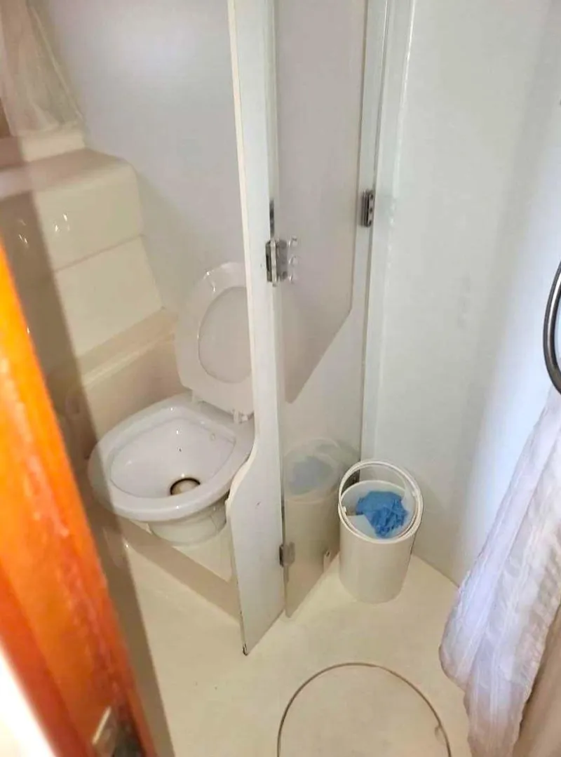 Slide: The Image of 1998 Viking Sports Cruiser bathroom with toilet, shower, and waste bin. - 27