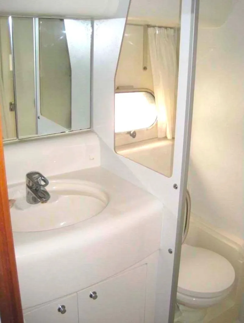 Slide: The Image of Bathroom interior of a 1998 Viking Sports Cruiser with sink, mirror, and toilet. - 29