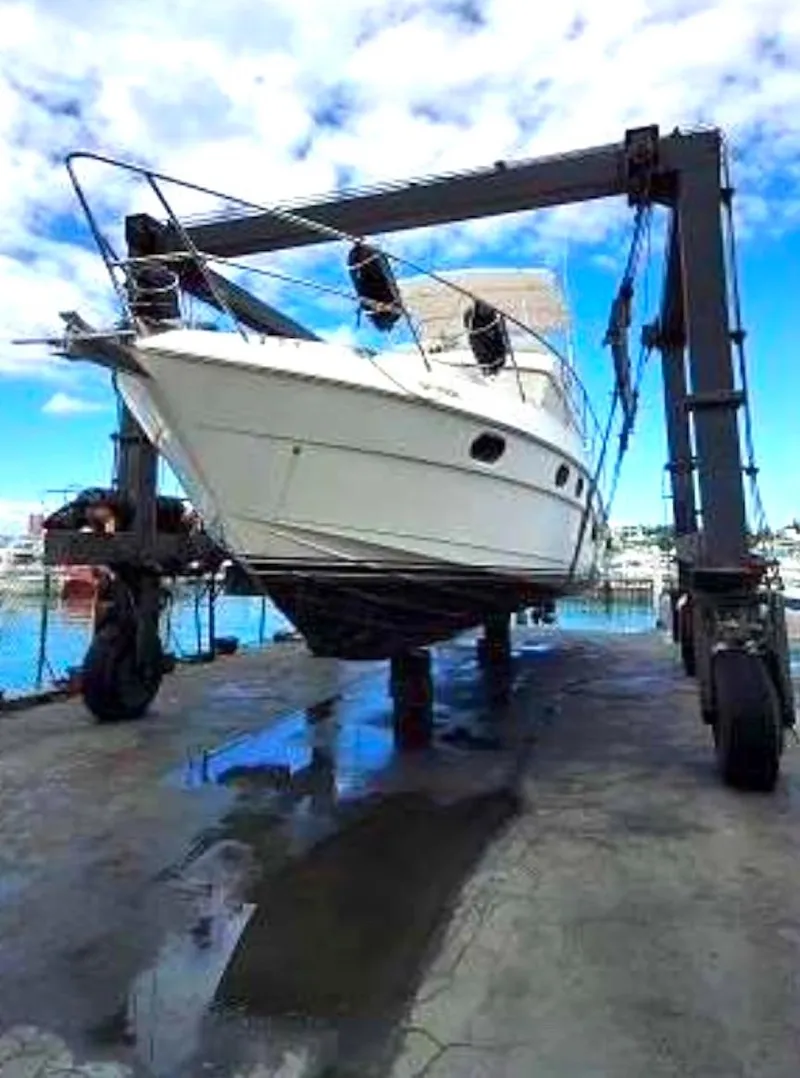 Slide: The Image of 1998 Viking Sports Cruiser on a lift at a marina, under a clear blue sky. - 3