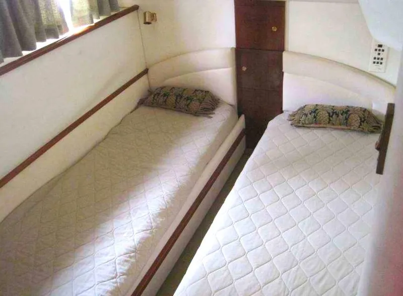 Slide: The Image of Twin beds in 1998 Viking Sports Cruiser cabin, featuring white bedding and decorative pillows. - 32