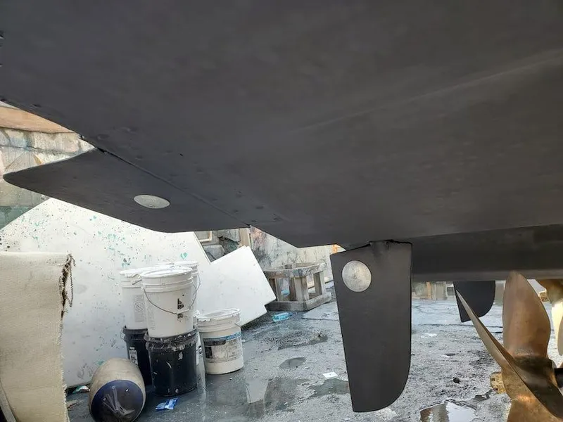 Slide: The Image of 1998 Viking Sports Cruiser hull with rudder, in a workshop setting. - 34