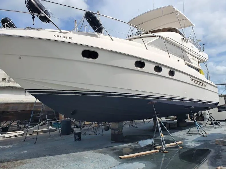 Slide: The Image of 1998 Viking Sports Cruiser yacht on dry dock for maintenance under a clear sky. - 5
