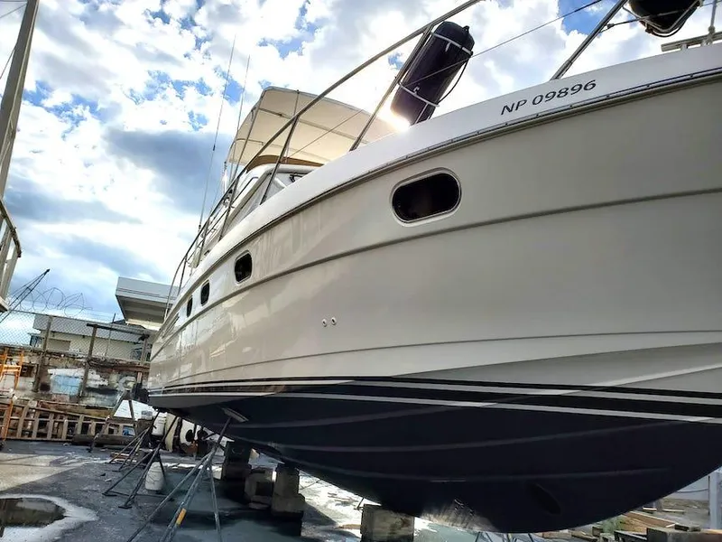 Slide: The Image of 1998 Viking Sports Cruiser yacht on dry dock under a cloudy sky. - 6