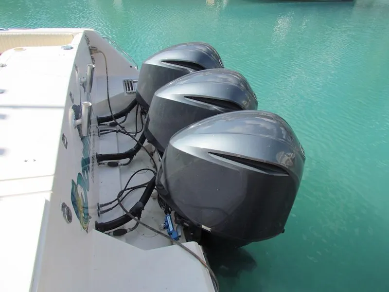 Slide: The Image of Triple outboard motors on a 2008 Grady-White Express 360 in turquoise water. - 12