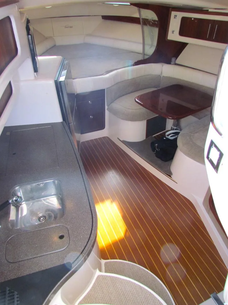 Slide: The Image of 2008 Grady-White Express 360 interior with kitchenette, seating area, and wooden flooring. - 16