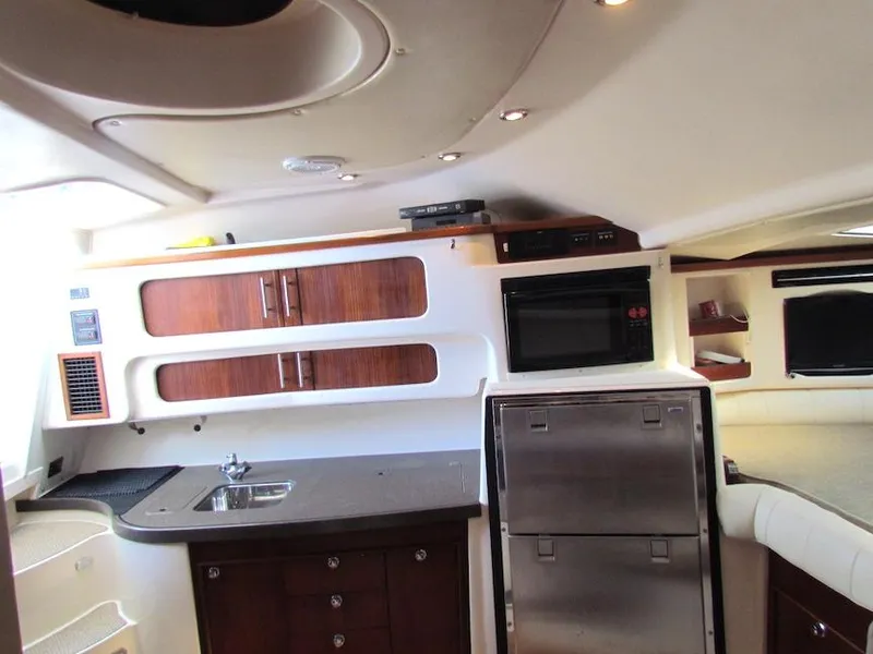 Slide: The Image of 2008 Grady-White Express 360 interior with kitchenette, wood cabinets, and modern appliances. - 19