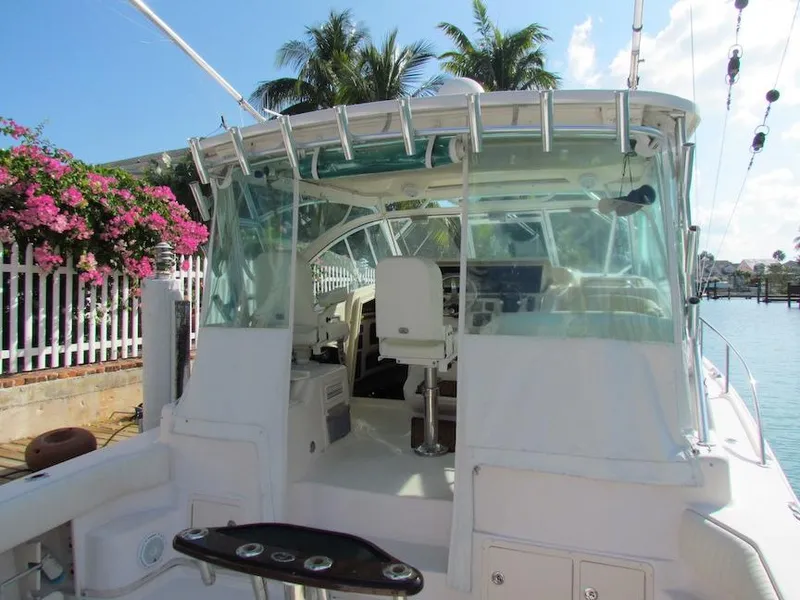 Slide: The Image of 2008 Grady-White Express 360 boat docked, featuring cockpit and helm, with tropical backdrop. - 28