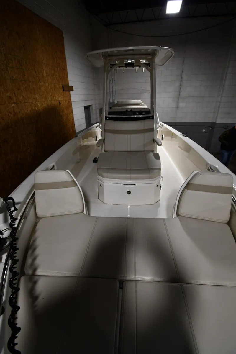 Slide: The Image of 2022 Boston Whaler 250 Dauntless boat interior with cushioned seating and center console. - 13