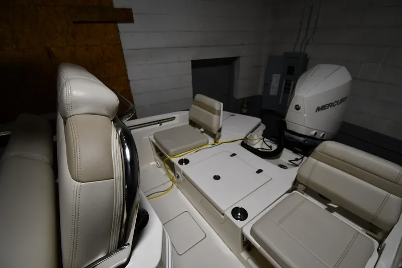 Slide: The Image of 2022 Boston Whaler 250 Dauntless interior with seating and Mercury engine in a garage. - 26