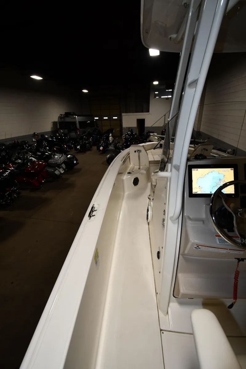 Slide: The Image of 2022 Boston Whaler 250 Dauntless boat interior with navigation display in a dimly lit storage area. - 31