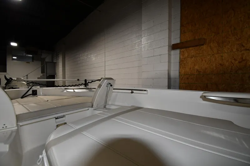 Slide: The Image of 2022 Boston Whaler 250 Dauntless interior with white seating in a dimly lit space. - 32