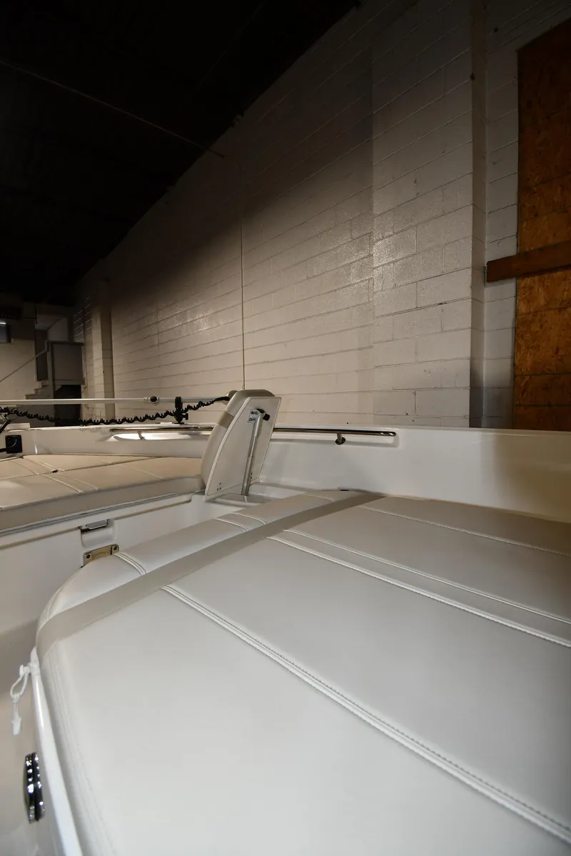 Slide: The Image of 2022 Boston Whaler 250 Dauntless interior with white seating in a warehouse. - 33