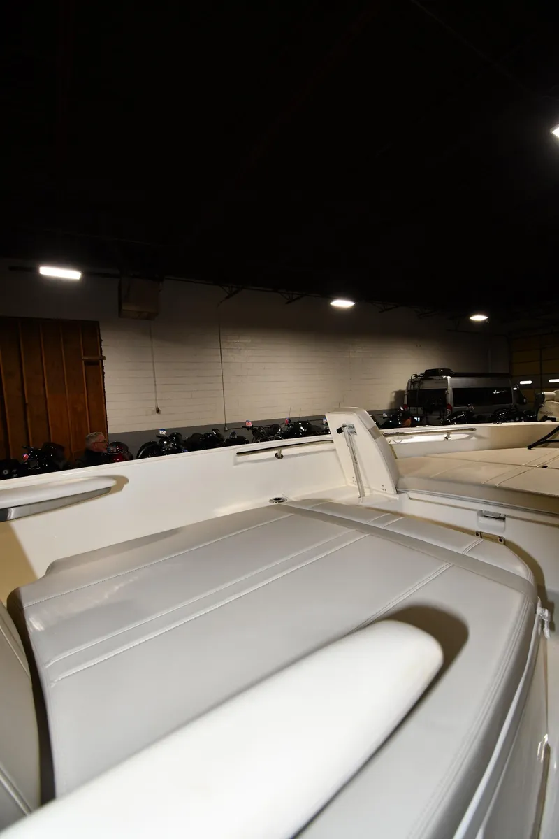 Slide: The Image of 2022 Boston Whaler 250 Dauntless boat interior in a dimly lit showroom. - 35