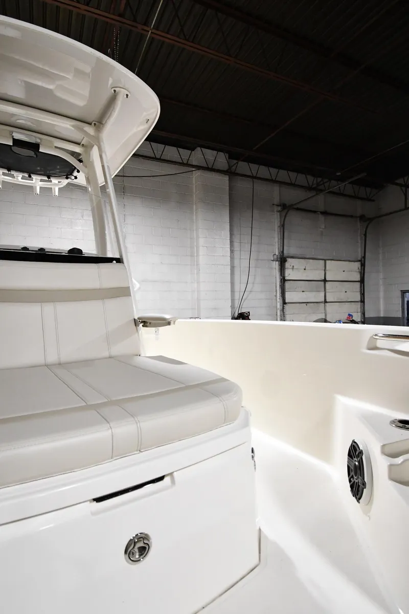 Slide: The Image of 2022 Boston Whaler 250 Dauntless interior, showcasing seating and storage in a warehouse setting. - 37