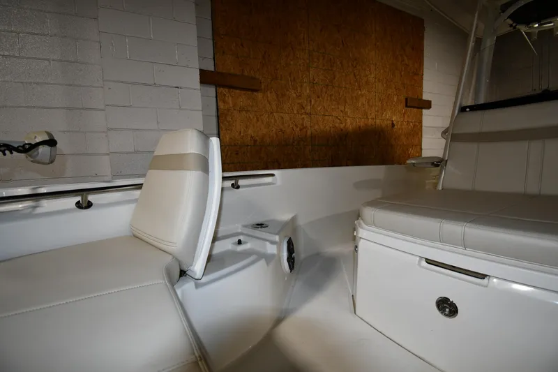 Slide: The Image of Interior of 2022 Boston Whaler 250 Dauntless boat, featuring white seating and storage compartments. - 38