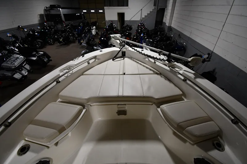 Slide: The Image of 2022 Boston Whaler 250 Dauntless boat interior in a dimly lit garage. - 9