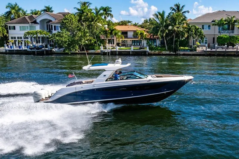 Slide: The Image of 2019 Sea Ray SLX 400 Outboard cruising on a sunny waterfront near luxury homes. - 10