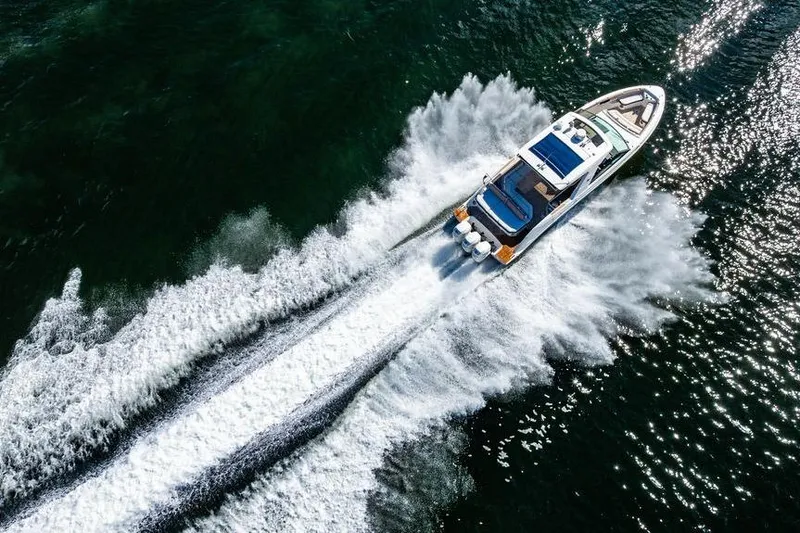 Slide: The Image of 2019 Sea Ray SLX 400 Outboard cruising on open water, creating dynamic wake patterns. - 11