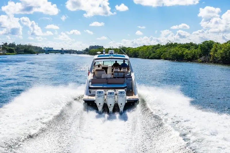 Slide: The Image of 2019 Sea Ray SLX 400 Outboard cruising on a sunny day, creating a wake in the water. - 12