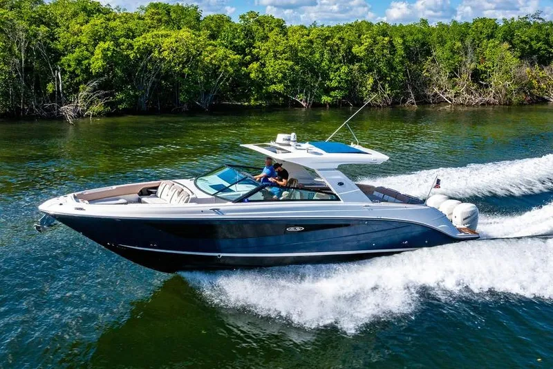 Slide: The Image of 2019 Sea Ray SLX 400 Outboard cruising on a scenic waterway with lush greenery. - 15
