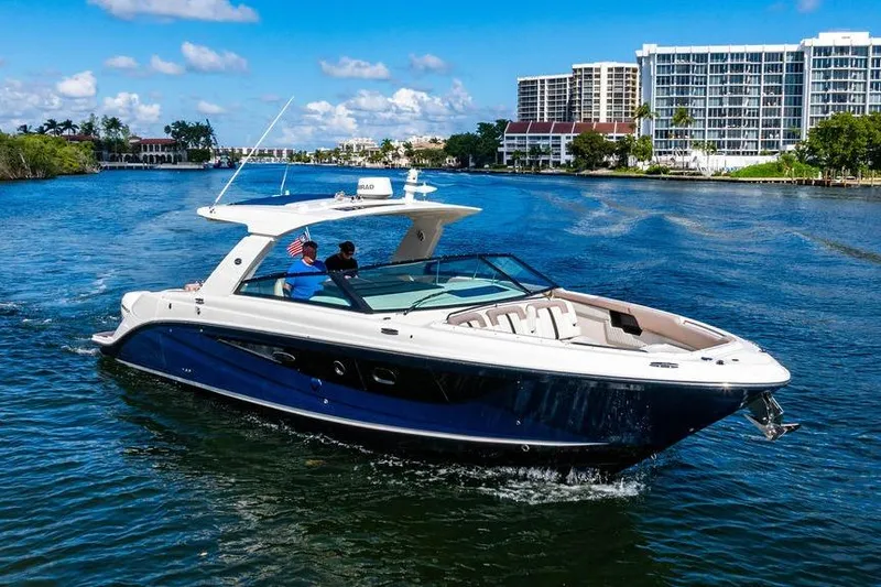 Slide: The Image of 2019 Sea Ray SLX 400 Outboard cruising on a sunny day near waterfront buildings. - 18