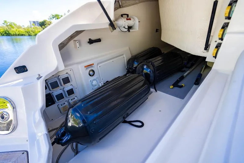 Slide: The Image of 2019 Sea Ray SLX 400 Outboard storage compartment with black fenders and equipment. - 23