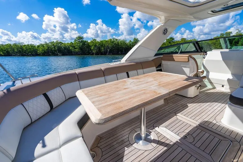 Slide: The Image of Luxurious 2019 Sea Ray SLX 400 Outboard boat interior with elegant seating and wooden table. - 29