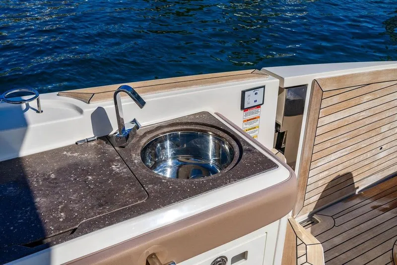Slide: The Image of Luxury 2019 Sea Ray SLX 400 Outboard boat with sleek outdoor sink and wooden deck. - 30