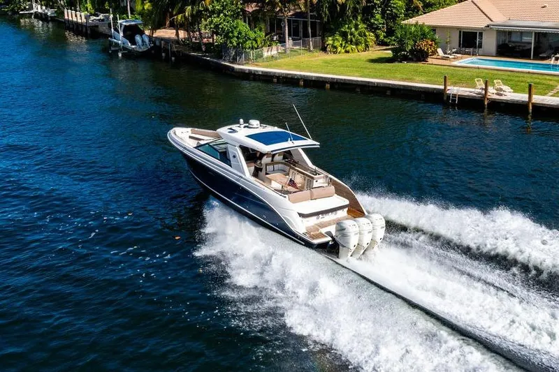Slide: The Image of 2019 Sea Ray SLX 400 Outboard cruising on a scenic waterway near waterfront homes. - 4